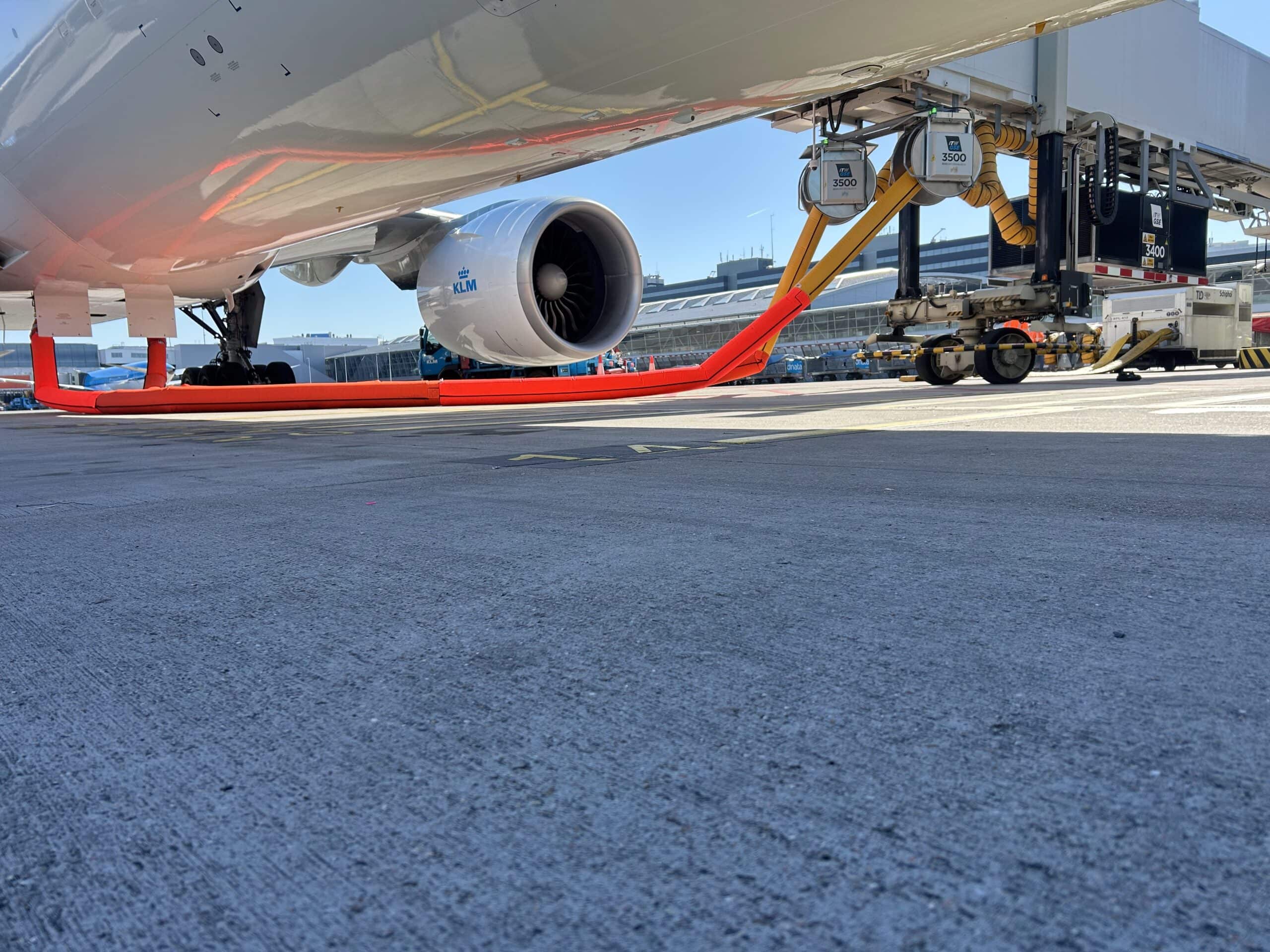 from below an aircraft you see a passenger boarding bridge equipted with a pca and two air coils from where the hoses are connected to the aircraft.