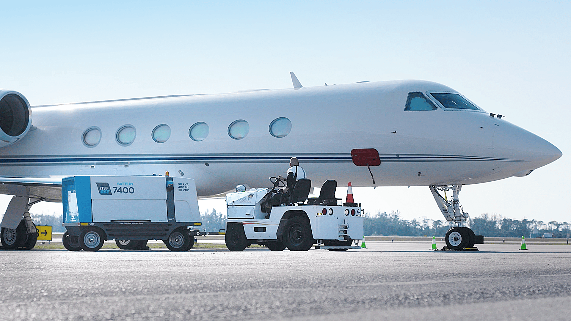 an itw gse 7400 eGPU 90kVA being towed towards an aircraft on a remote stand