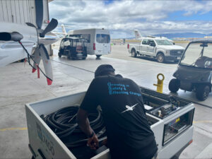 an eployee from itw gse standing in an hangar working on an itw gse 7400 jetex ground power unit 